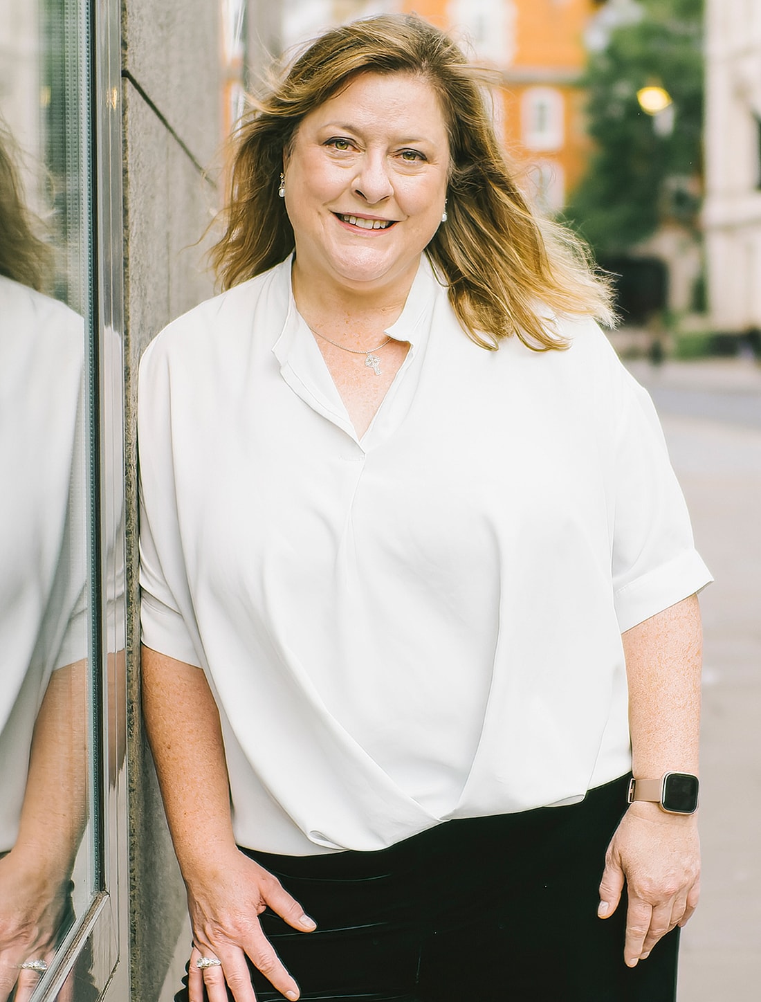 Smiling woman in casual outfit by the street.
